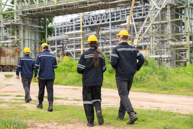 Engineer workers walking and talking to petrochemical industry or refinery oil plant factory.