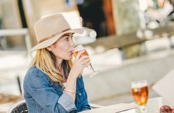 woman drinking sitting in outside cafe