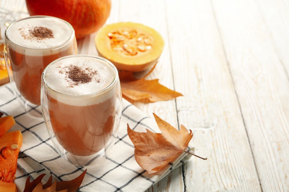 Composition with pumpkin latte on wooden table
