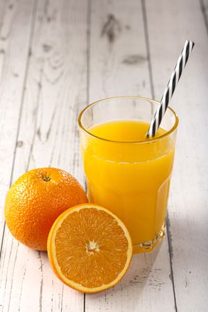 Glass with orange juice on the table.