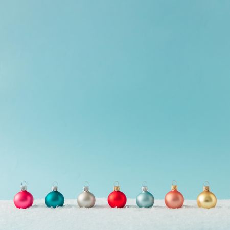 Row of Christmas bauble decorations on snow