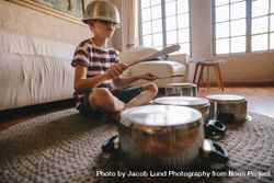 Boy playing drums on kitchenware at home 5ra2l0