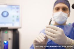 Doctor holding surgery tools while wearing latex gloves 0K1pY4