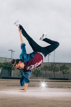 Skillful break dancer performing handstand while moving