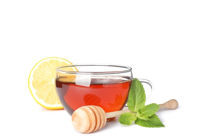 Cup of tea, lemon, mint and dipper isolated on plain background
