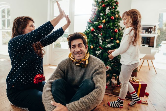 Family having fun together in front of Christmas tree