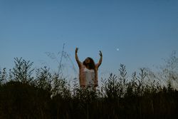 Happy woman raising arms to sky