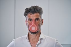 Serious adult male in protective mask looking at camera