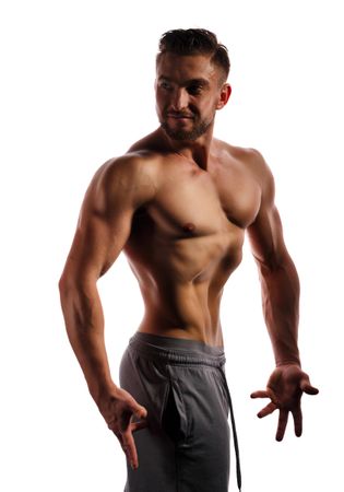Bodybuilder competitor turned around practicing upper body poses in bright studio