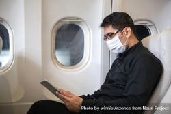 Businessman in suit checking digital tablet in airplane 4mlrX5