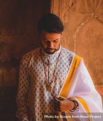 Portrait of man wearing traditional Indian clothing looking down 5nmG60