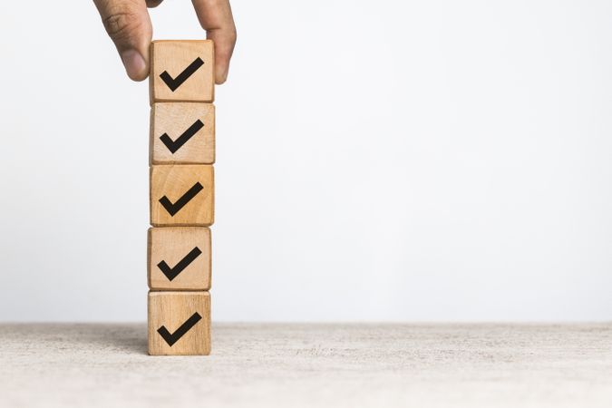 male hand put wooden blocks with checkmark symbol