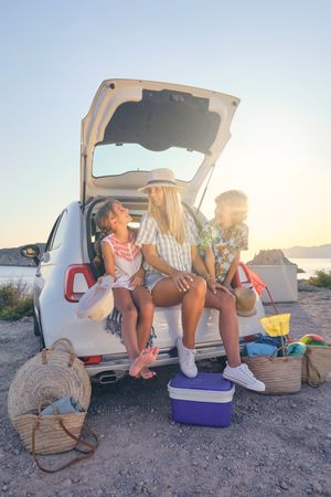 Vertical photo of a mother with her two children in straw hats s