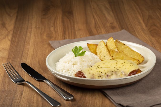 Parmigiana steak with rice and roasted potatoes. Typical Brazilian dish.