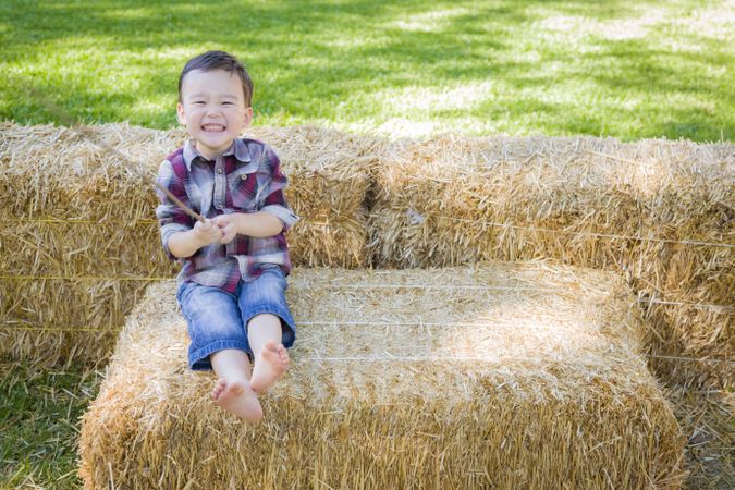 Cute Boy Having Fun on Hay Bale