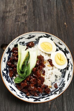 Top view of pork and rice dish on wooden table