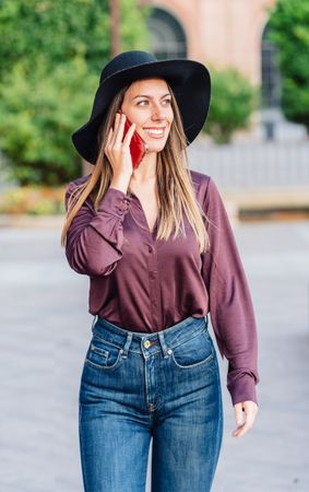 Woman in trendy outfit talking on smartphone
