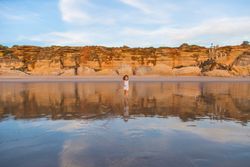 Little girl walking on water of beach seashore