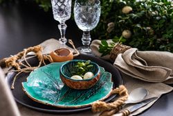 Easter table setting with teal bowl of decorative eggs