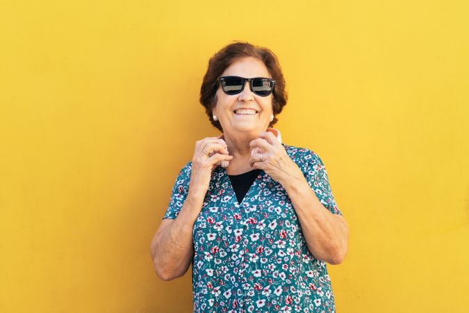 Stylish mature woman in sunglasses and colorful clothes