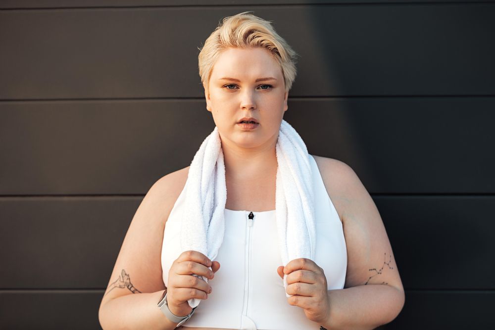 Blonde woman in workout gear with towel around her neck