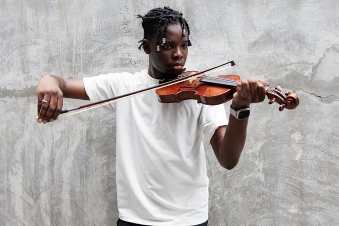 Black man playing on violin.