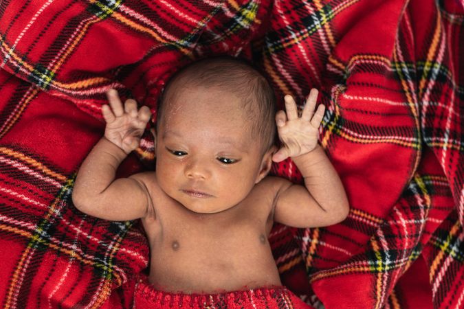 Newborn baby on soft tartan blanket