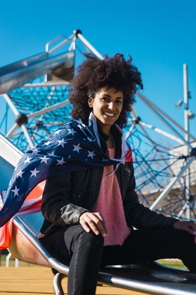 Black woman with afro hair and an american flag.