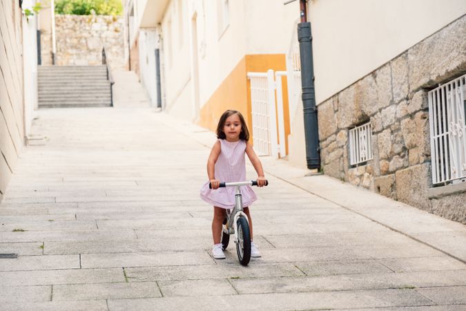 Girl riding on bicycle in narrow street