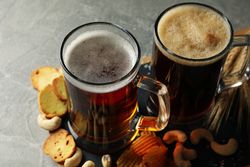 Beer, wheat and snacks on gray table