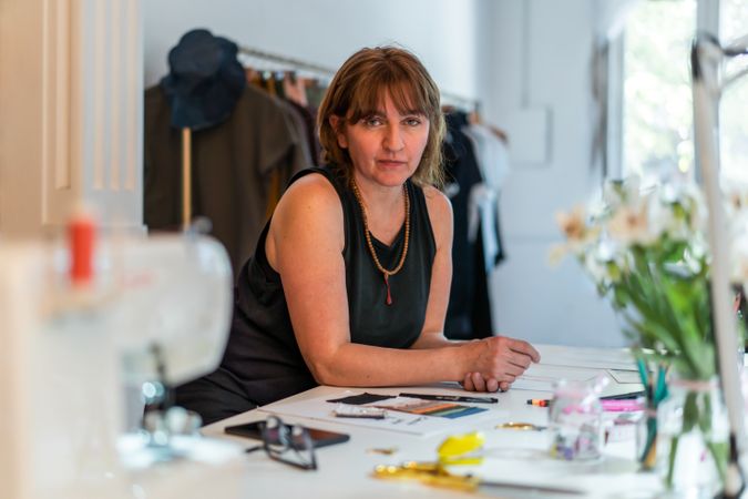 Woman sitting at work desk in garment business