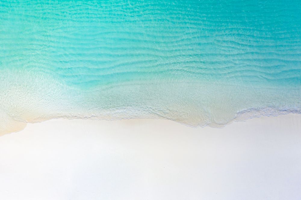 Aerial shot of clear water at a tropical, idyllic beach