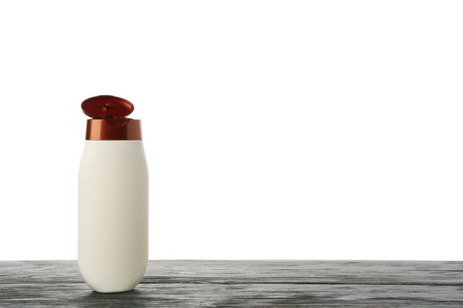 Blank shampoo bottle on wooden table isolated on light background