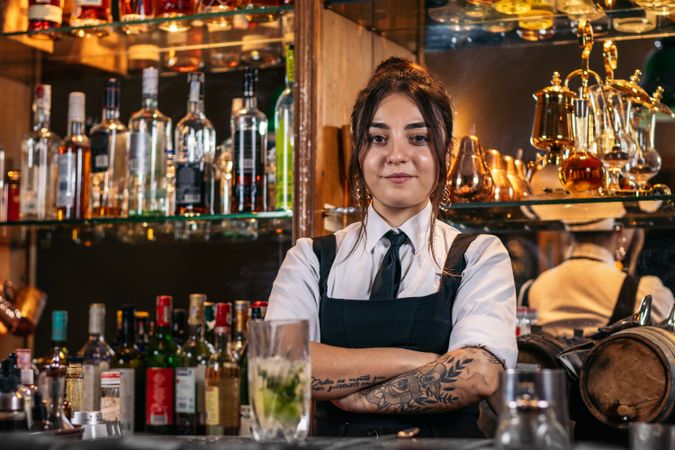 Portrait of a young female bartender in a traditional cocktail bar