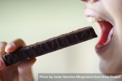 Anonymous girl with open mouth about to eat chocolate bar beXoxq