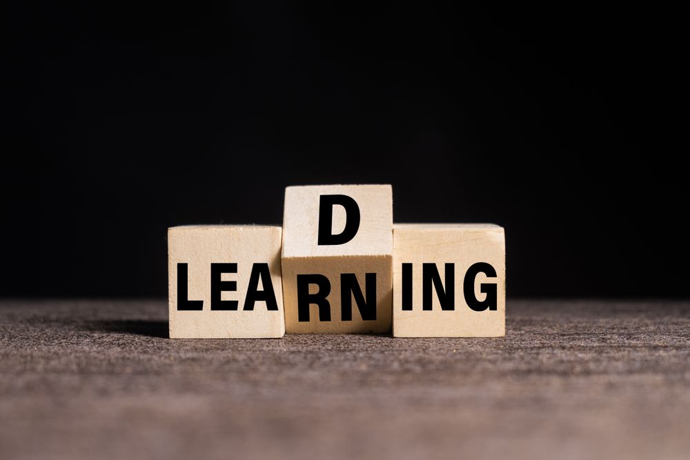 leading and learning words symbol on wooden blocks on dark dark background