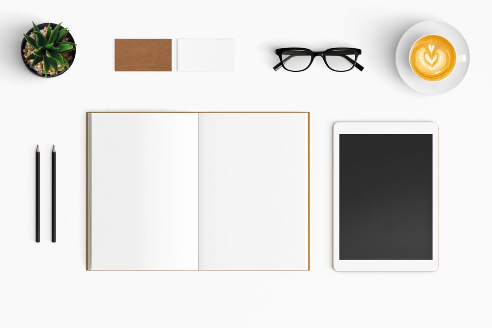 Modern workspace with coffee cup, smartphone, paper, notebook, tablet copy space