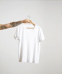 Arm holding a light t-shirt on hanger