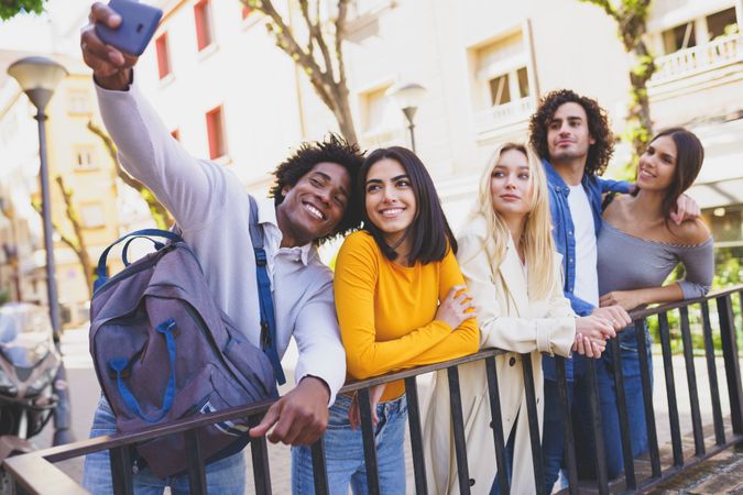 Multi-ethnic friends taking selfies together outside