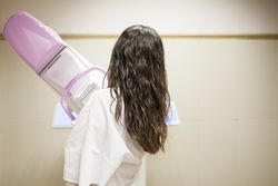 Female patient beside digital mammography unit
