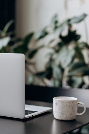 Modern Workspace with Laptop and Coffee Cup on Table
