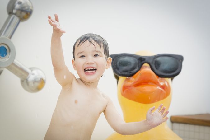 Biracial happy boy playing at the water park