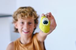 Happy child showing painted stone to camera