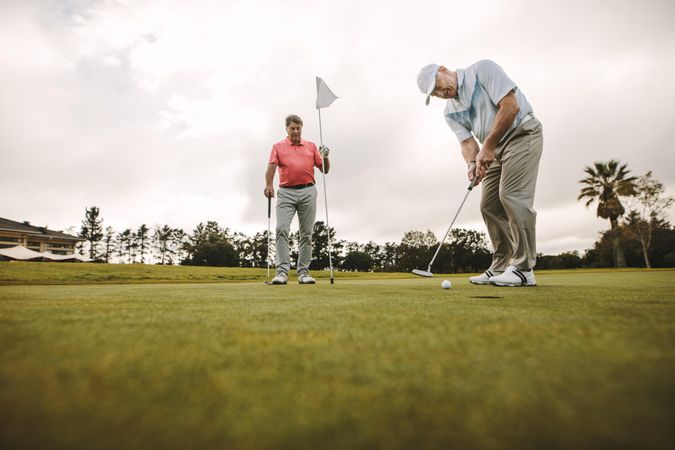Older retired friends enjoying a round of golf together