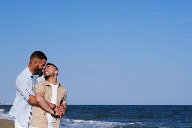 Gay couple kissing on beach