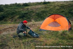 Man pitching tent in field bD8KVb