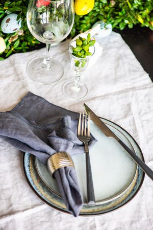 Spring table setting with plates on table with lush centerpiece
