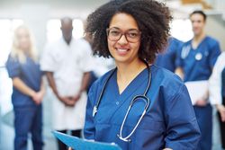 Portrait of smiling Black woman in scrubs and stethoscope