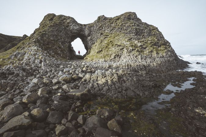 Woman standing inside rocky cave