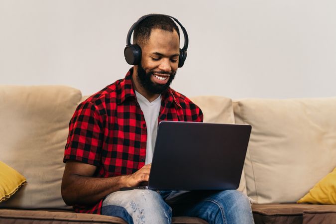Black man teleworking with laptop from home